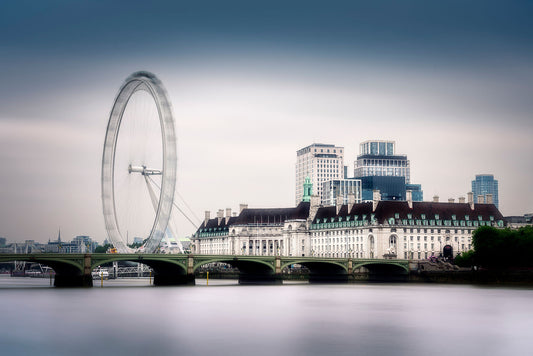 Fine art photograph of the London Eye and County Hall across the River Thames on a calm winter morning, with smooth water and a misty sky.